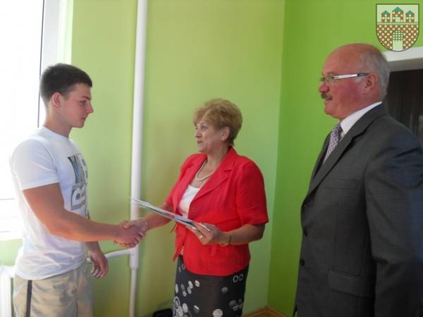 : Sebastian Pawlik przyjmuje gartulacje od przewodniczacej Stanisławy Nowak i burmistrza Klemensa Podlejskiego.